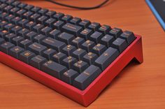 a computer keyboard sitting on top of a wooden desk