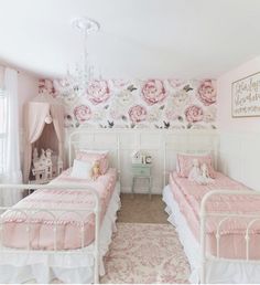 two twin beds in a pink and white bedroom