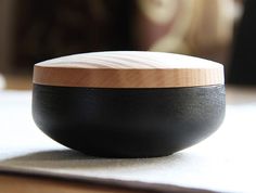 a wooden and black bowl sitting on top of a table