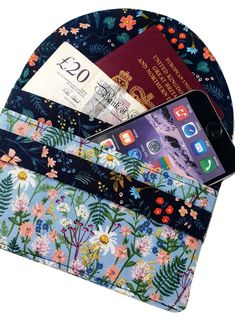 an iphone and passport are in the pocket of a purse that is decorated with flowers