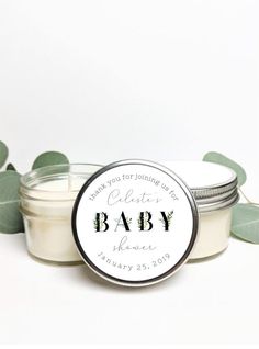 a small jar filled with baby candles sitting on top of a white table next to green leaves