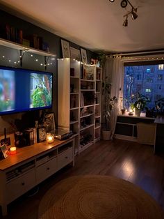 a living room filled with furniture and a flat screen tv mounted on a wall next to a window