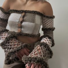 a woman with white hair wearing an off the shoulder sweater and crochet gloves