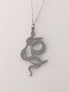 This Crescent Moon Snake Necklace is the perfect way to show your unique style. Featuring a crescent moon and serpent design, this striking piece of occult jewelry will make the perfect statement. Add a hint of mystery and allure to your look with this gorgeous crescent moon snake necklace. You'll feel confident and powerful wearing this one of a kind piece of jewelry. With its unique and intricate design, you'll stand out from the crowd and showcase your individual style. Get ready to take your Spiritual Metal Jewelry In Snake Shape, Spiritual Snake-shaped Metal Jewelry, Symbolic Crescent Metal Jewelry, Silver Symbolic Snake-shaped Necklace, Silver Snake Necklace With Symbolic Style, Symbolic Black Crescent Jewelry, Snake Necklace, Crescent Moon, Individual Style