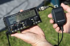 a person holding a radio in their hand and an electronic device connected to the other