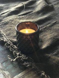 a candle sitting on top of a blanket