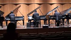 a group of men playing piano on stage