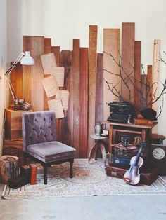 a living room filled with lots of furniture and wooden panels on the wall behind it