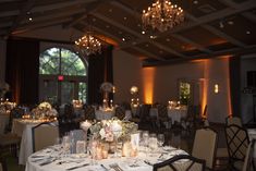 a dining room with chandeliers and tables set up for an elegant dinner party