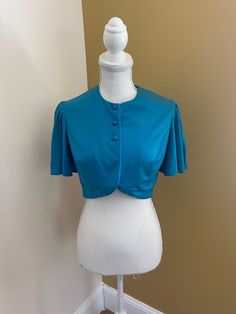 Fun vintage 70's bolero/capelet, very disco. Would be super cut over a dress, or as a crop top with high waisted jeans. Bust 38" Top to bottom 15" Fitted Tops For Vintage Fashion In Summer, Fitted Vintage Fashion Summer Blouse, Fitted Cropped Ruffle Blouse, Chic Fitted Summer Shrug, Fitted Vintage Crop Top For Summer, Fitted Ruffled Crop Top For Evening, Fitted Tops With Cape Sleeves, Vintage Fitted Crop Top For Spring, Fitted Blue Ruffle Crop Top