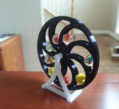 a wooden table topped with a black and white spinning wheel