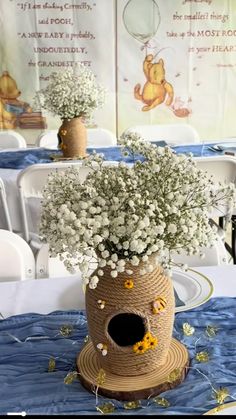 a vase filled with baby's breath sitting on top of a blue table cloth