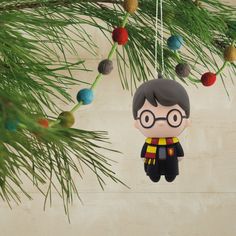 a harry potter ornament hanging from a christmas tree with pine needles and ornaments