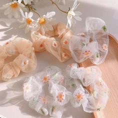 several scrunffles on a wooden tray with flowers and daisies in the background