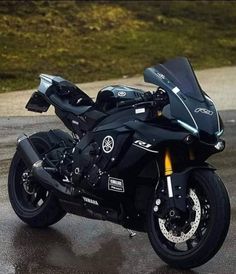 a black motorcycle parked on top of a wet parking lot