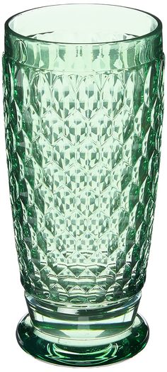 a green glass vase sitting on top of a table