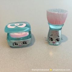 two small toy brushes sitting on top of a white counter next to each other,