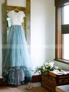 a dress hanging on a wall next to a window