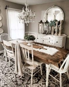 a dining room table with white chairs and a chandelier