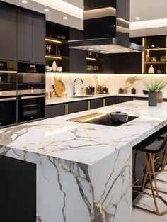 a modern kitchen with marble counter tops and black cabinets, along with bar stools