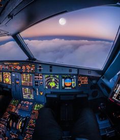 the view from inside an airplane looking out at the clouds and moon in the sky