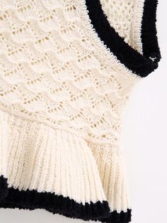 a white and black knitted sweater hanging on a wall