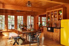 a kitchen with wood paneling and yellow refrigerator