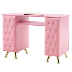 a pink desk with gold legs and a laptop on top