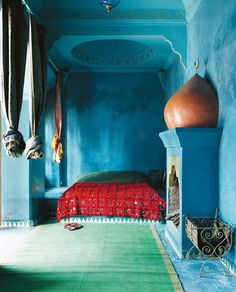 an instagram photo of a bedroom with blue walls and red bedspread on the bed