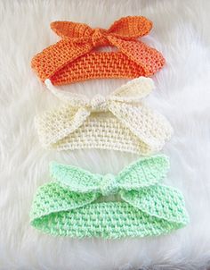 three crocheted bow ties laying on top of a white furnishing area