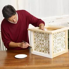 a man is working on an intricate wooden box