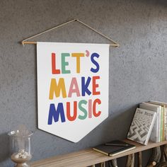 a sign that says let's make music hanging on the wall above a shelf