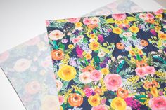 two pieces of fabric with flowers on them sitting next to each other and one piece has been folded over