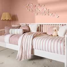 a bed with pink walls and white furniture