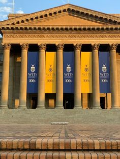 an old building with columns and banners on the front