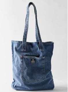 a denim bag with an open pocket on the front and side, sitting against a white background