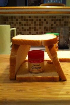 a sandwich sitting on top of a wooden table next to a jar of peanut butter