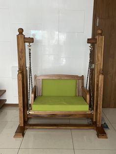 a wooden swing bed with green cushions