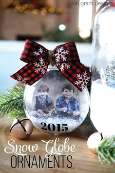 a snow globe ornament with two children in it on a table next to christmas decorations