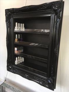 an ornate black shelf with many bottles on it and a mirror in the corner behind it