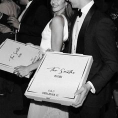 a man and woman are holding two pizza boxes