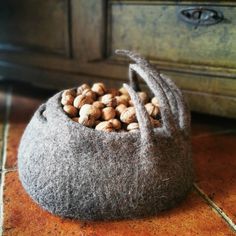 a bag filled with nuts sitting on top of a floor next to a wooden dresser