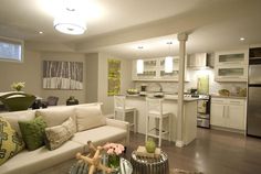 a living room filled with furniture next to a kitchen