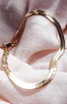 A classic piece for your collection, the Konani Herringbone Chain Bracelet is a stunning addition. Made from 18kt Gold Filled, this versatile, retro bracelet is a striking statement worn alone or with a bevy of other beauties. Wear it solo or stack it with our other bracelets.This chain style is delicate; be careful not to bend, squeeze, or fold as it may permanently damage the chain. Always store it flat to keep it protected.Handmade on Maui, Hawaii.✦ DETAILS ✦✧ Name: Konani (koh-NAH-nee) - shi Elegant Metal Charm Bracelet With Snake Chain, Metal Snake Chain Bracelet With Adjustable Chain, Tarnish Resistant Metal Snake Chain Bracelets, Gold Snake Chain Bracelet As Gift, Gold Snake Chain Bracelet For Gift, Elegant Snake-shaped Chain Bracelet Gift, Metal Snake Chain Bracelet As Gift, Tarnish Resistant Snake Chain Bracelet, Gold Snake Chain Bracelet With Adjustable Chain