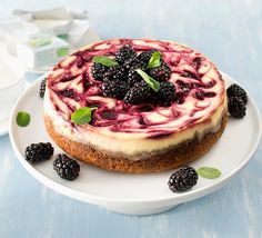 a cheesecake topped with berries and blackberries on a plate