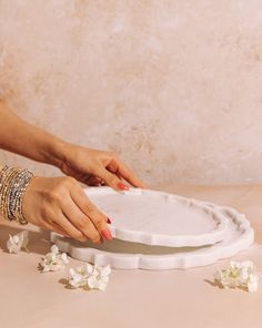 a woman is placing flowers on a plate