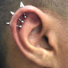 a close up of a person's ear with three piercings on the side