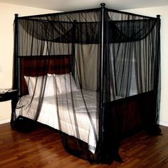 a four poster bed with mosquito netting on it