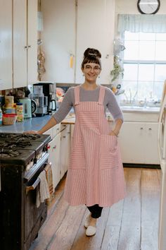 a woman standing in a kitchen next to an oven