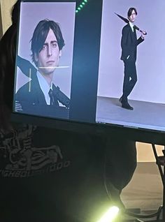 a man in a suit and tie is looking at two images on a computer screen